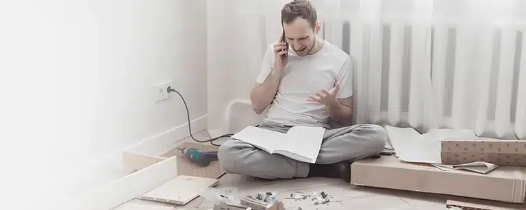 Un homme énervé en train de monter un meuble Un homme énervé en train de monter un meuble