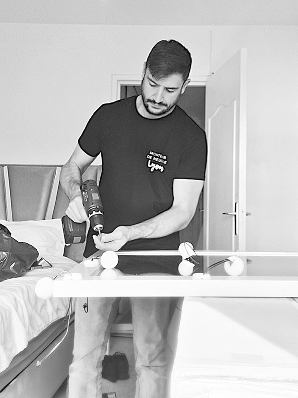 Selman en train de monter un meuble à domicile